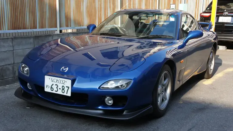Front view of a rented blue Mazda RX-7 in a coin parking in Nara, Japan