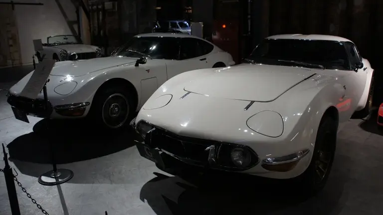 Two white Toyota 2000GT displayed next to each other inside the Glion Museum in Osaka, Japan