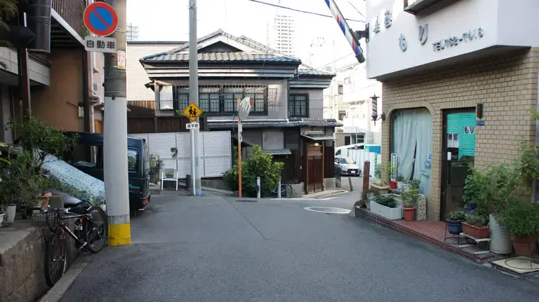 A small street featuring a streetlight on the edge of the road in Osaka, Japan