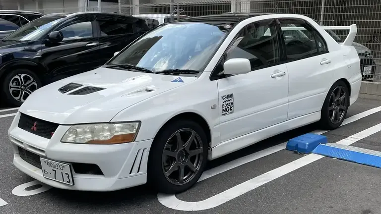 Rented white Mitsubishi Lancer Evolution 7 in a coin parking in Osaka, Japan