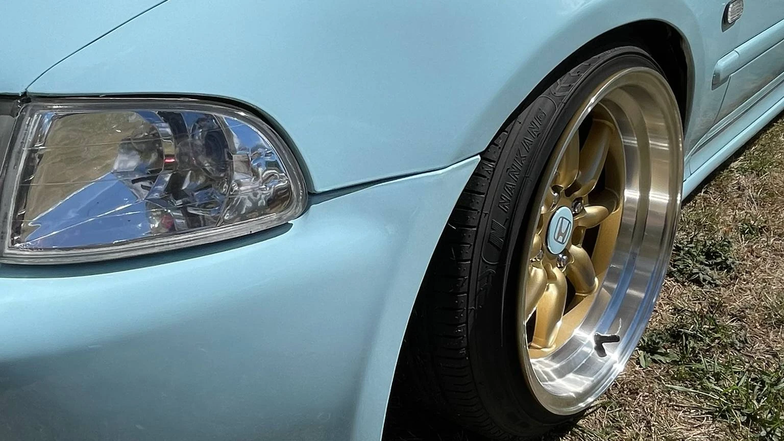Close-up view of a stanced pastel mint Honda Civic EJ1 wheel arch