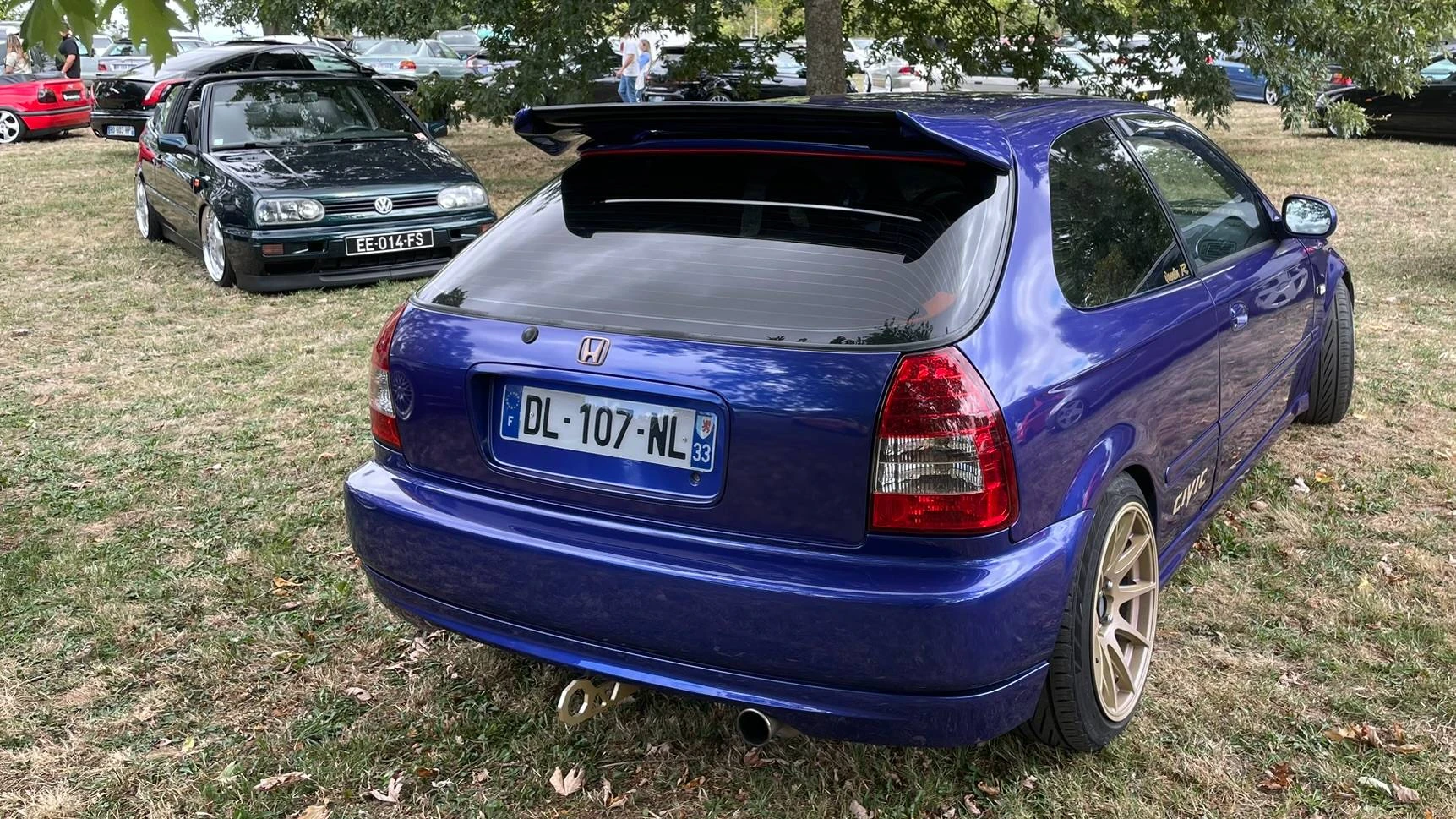 A stanced deep purple Honda Civic EK9 parked next to a stanced deep green Volkswagen Golf MK3