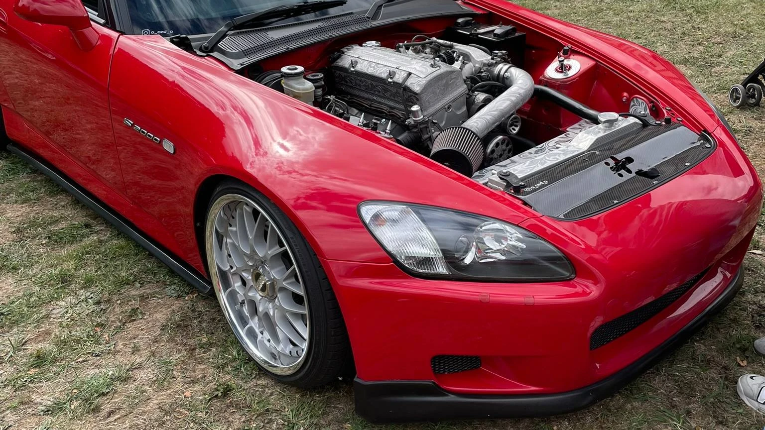 Front side view of a stanced red Honda S2000