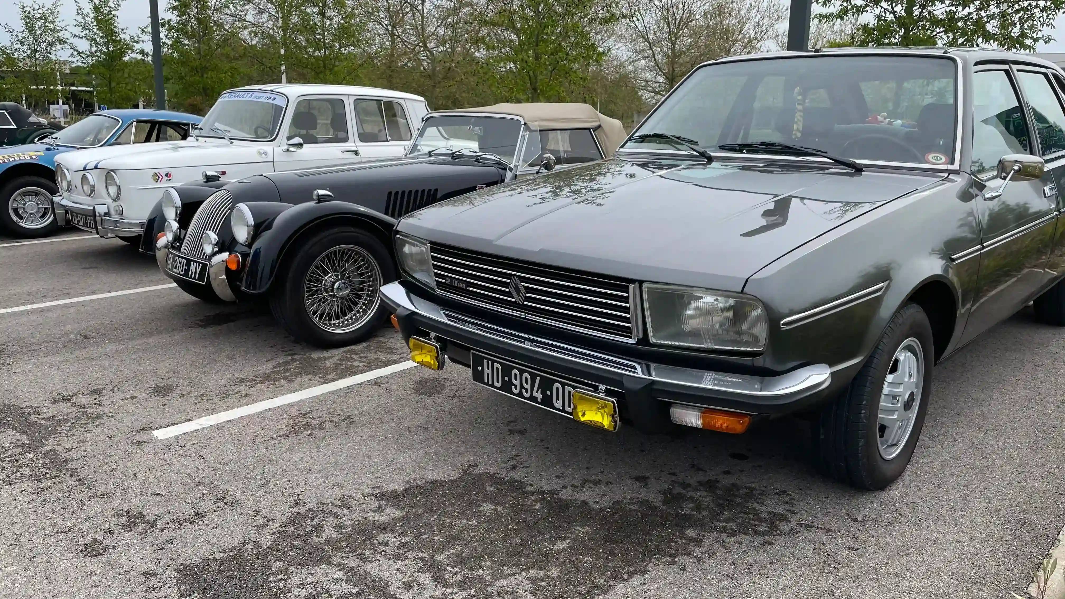 A dark green Renault 20, a black Morgan Plus 4, a white Renault 8 and a blue Alpine A110 all parked