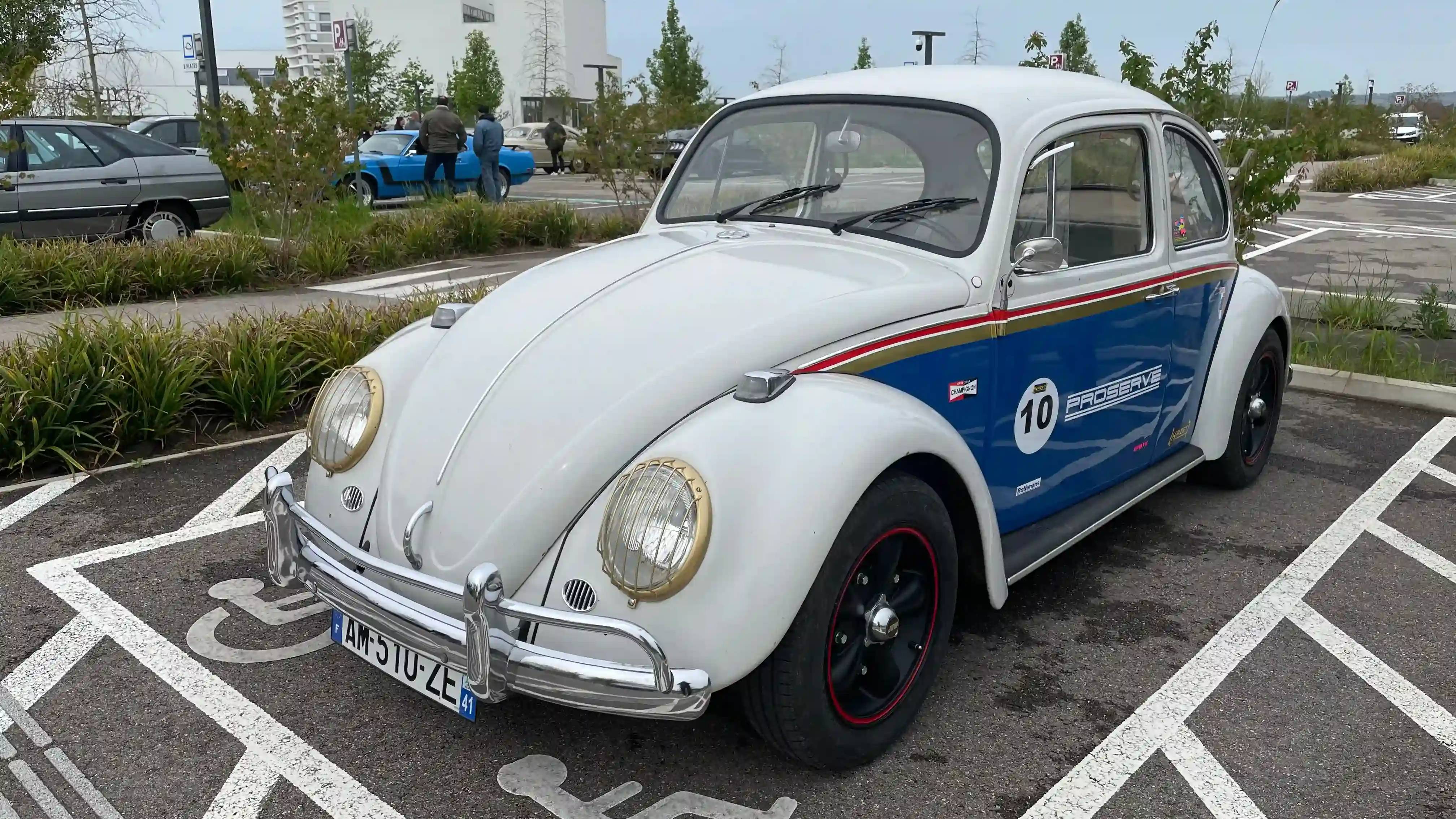A white Volkswagen Beetle with a racing Porsche livery