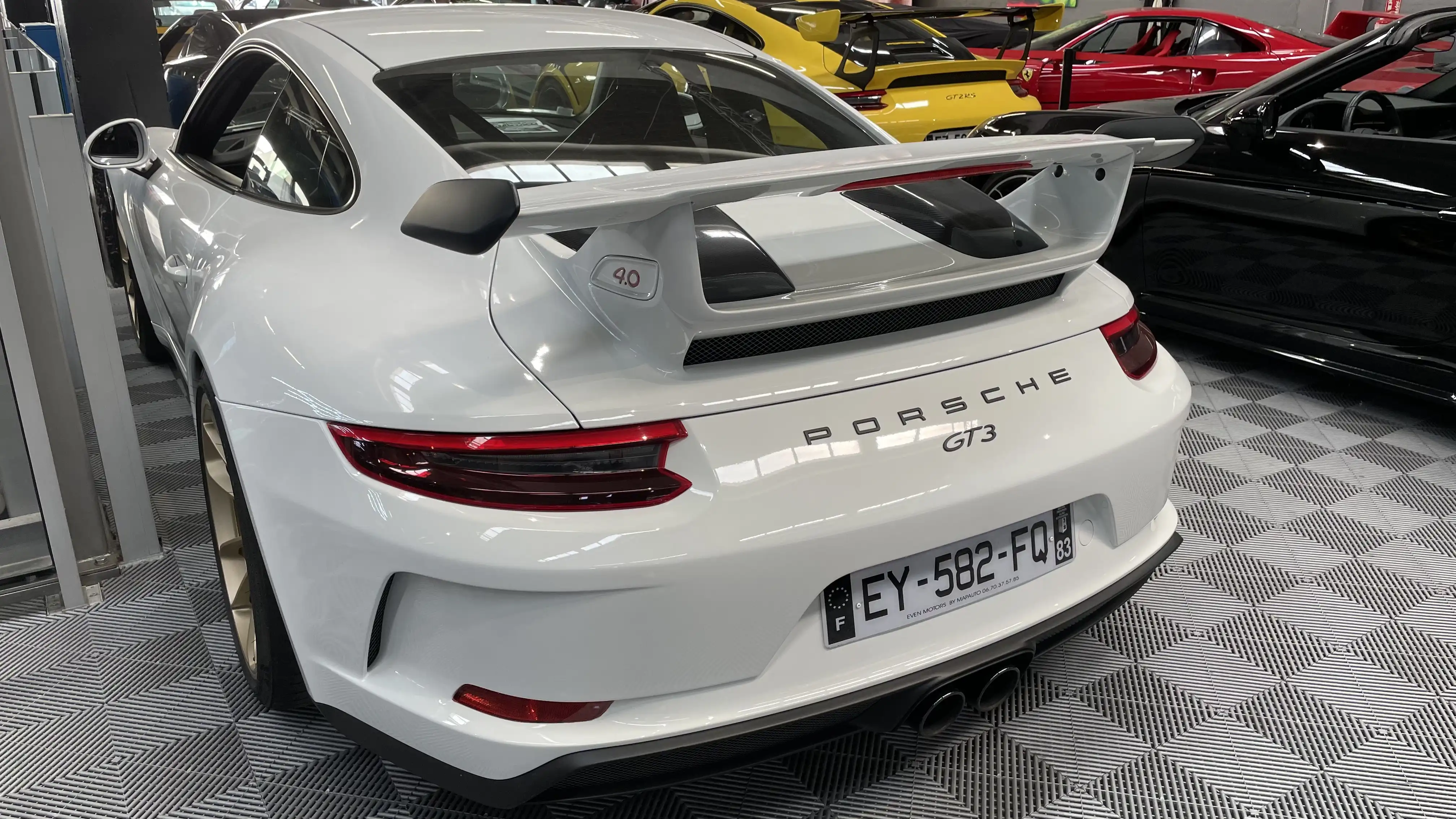 Rear view of a white Porsche GT3 inside the showroom of Dream Car Performance