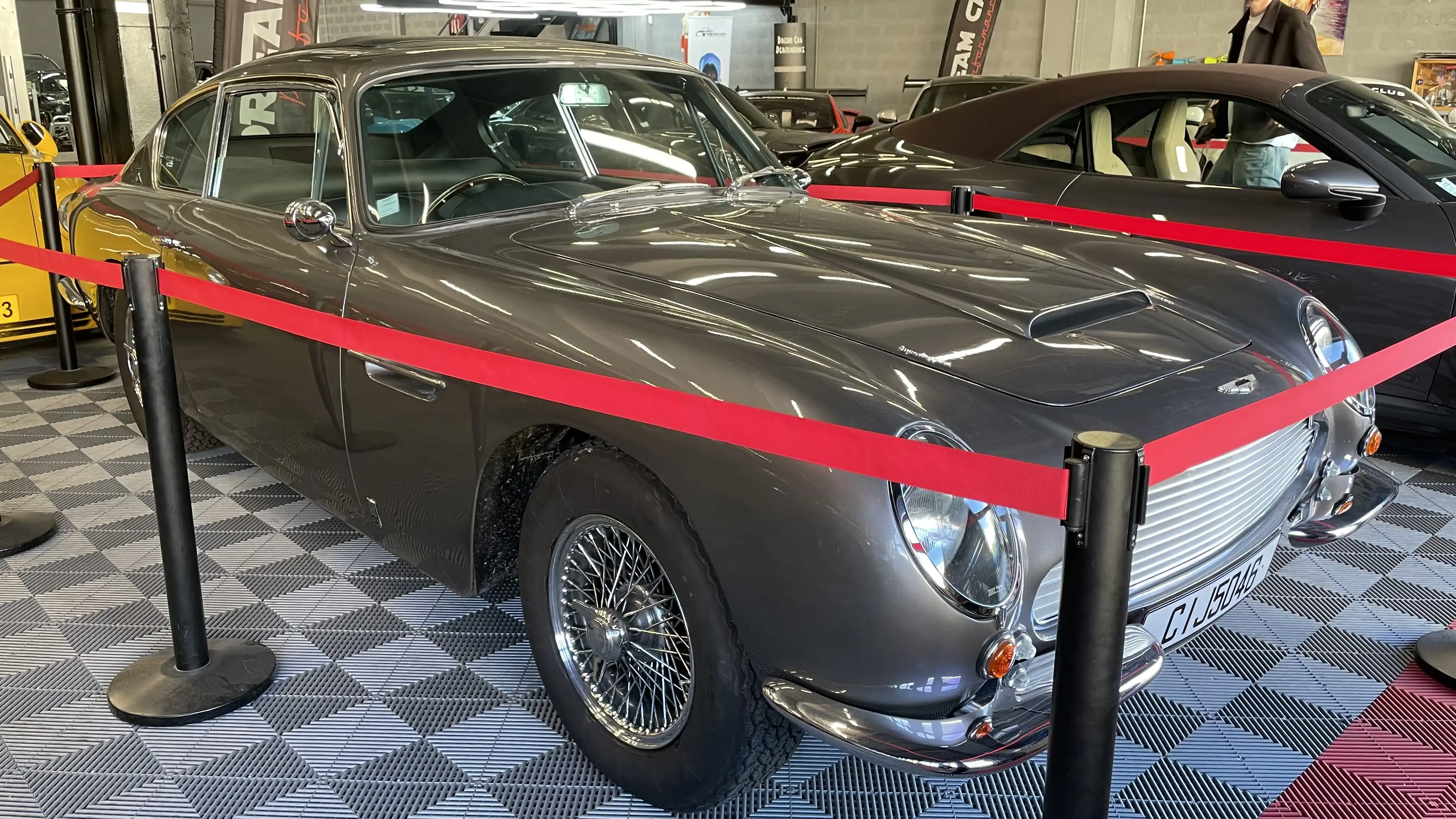 A grey Aston Martin DB6 inside the showroom of Dream Car Performance